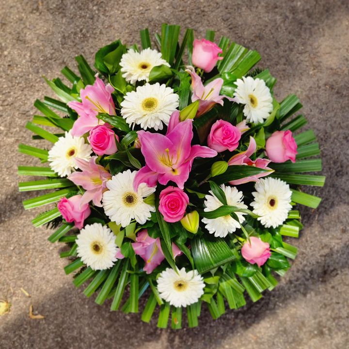 fekvő koszorú királyliliommal, gerberával és rózsával rózsaszín árnyalatban