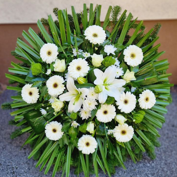Fehér színű álló koszorú; királyliliom, gerbera, rózsa és krizantém virágokkal.